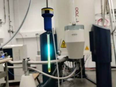 A glass fibre irradiating an NMR tube in front of an NMR spectrometer